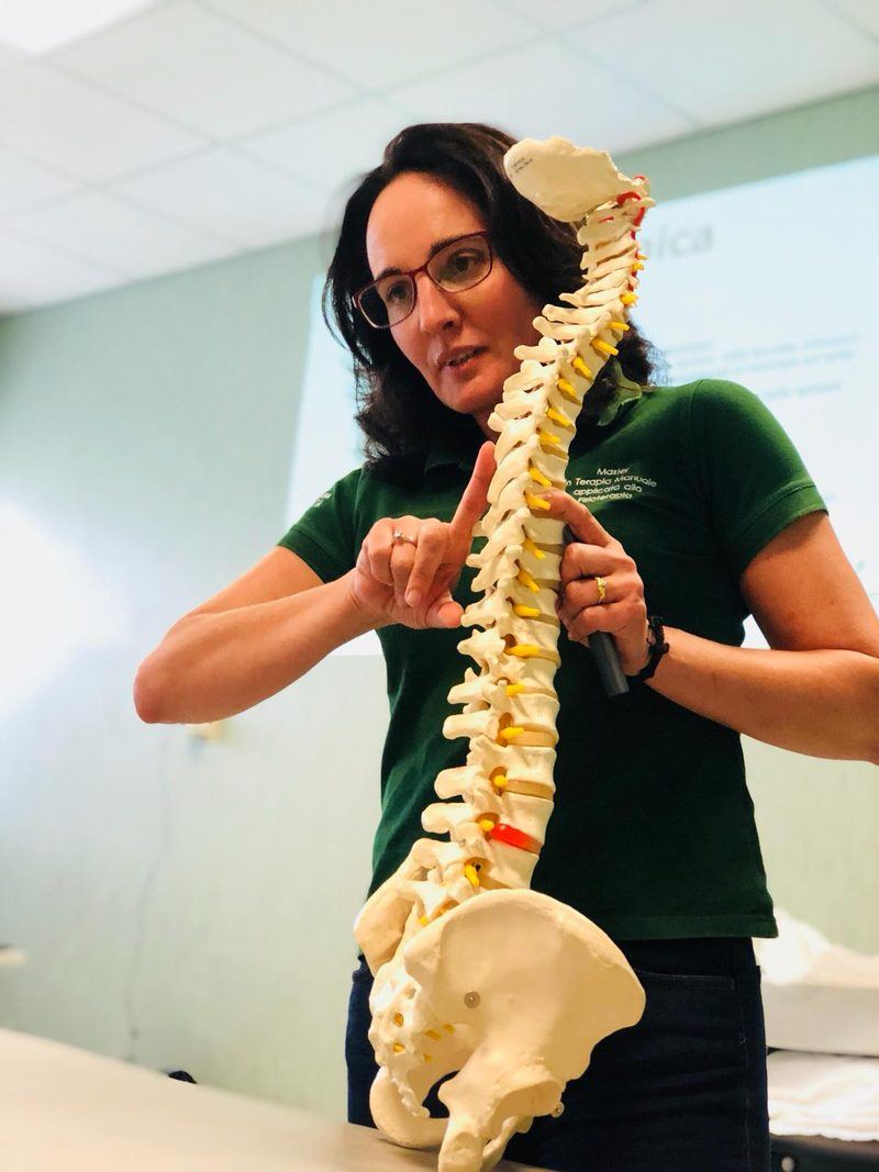 Francesca Bonetti, fisioterapista e titolare dello Studio Physioup, illustra l'anatomia della colonna vertebrale con un modello